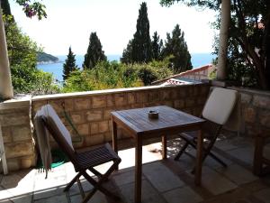 una mesa y sillas en un patio con vistas al agua en Apartments Emi en Dubrovnik