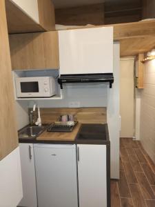 a small kitchen with white cabinets and a microwave at Studio 9M2 Champs Élysées Arc de Triomphe75008 Paris in Paris
