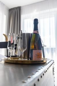 a bottle of wine on a tray with two wine glasses at Amazing Condo in Brașov by Valentino - Free Garage Parking in Braşov
