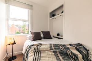 a white bedroom with a bed and a window at The Broadway Bath - 2 Bedrooms with parking, Central Bath in Bath