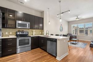 uma cozinha com electrodomésticos de aço inoxidável e uma sala de estar em 1BRModern Retreat-Mins to Med Center em Houston