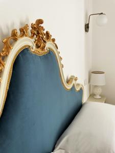 1 cama con cabecero azul y dorado en un dormitorio en B&B ISOLA Messina, en Messina