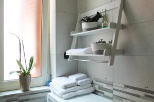 a bathroom with white towels on shelves and a window at GATTI e MARE in Salerno