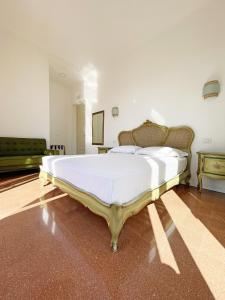 a bedroom with a large bed with white sheets at B&B ISOLA Messina in Messina