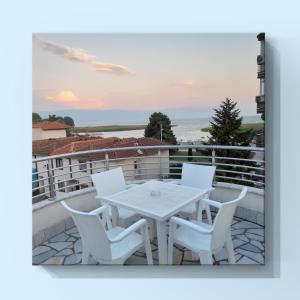 een witte tafel en stoelen op een balkon bij Ajro Rooms in Struga