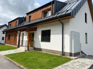 una casa blanca con techo negro en Apartmán - Dolní Morava - "Sedmička" pro 2 až 6 osob, en Dolní Morava