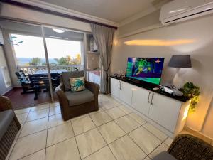 a living room with a flat screen tv and a couch at 196 Laguna La Crete in Uvongo Beach