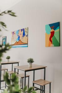 2 mesas y sillas en una habitación con pinturas en la pared en DOMUS MARINA Rooms en Nápoles