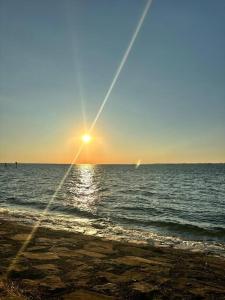 słońce zachodzące nad oceanem z plażą w obiekcie Stilvoll nah am See w mieście Lauterach