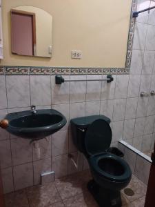 baño con aseo negro y lavamanos en HOTEL SOL Y LUNA, en Iquitos