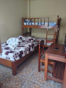 a bedroom with two bunk beds and a table at HOTEL SOL Y LUNA in Iquitos