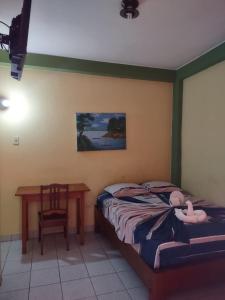 a bedroom with a bed and a table and a chair at HOTEL SOL Y LUNA in Iquitos