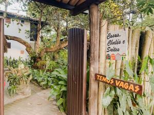 um sinal numa cerca de madeira com plantas em Pousada Zen Caraiva em Caraíva