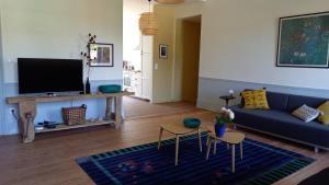 a living room with a blue couch and a tv at La Tour Bleue in Chânes