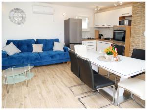 een woonkamer met een blauwe bank en een tafel bij House Luketini dvori in Blizna Donja
