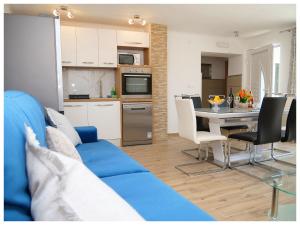 a living room with a blue couch and a table at House Luketini dvori in Blizna Donja