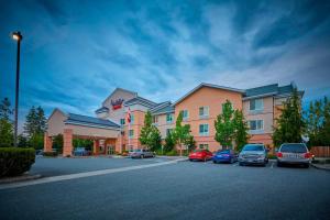 a hotel with cars parked in a parking lot at Fairfield Inn & Suites Burlington in Burlington