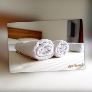 two towels on a bed in front of a mirror at Ajro Rooms in Struga
