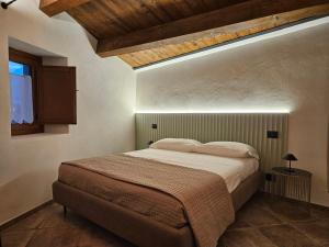 - une chambre avec un grand lit et un plafond en bois dans l'établissement DESTASU' Apartments, à Castel del Monte