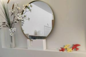 un espejo en un estante con un jarrón de flores en Sweet Domus & Terrace Citycenter, en Vila Nova de Famalicão
