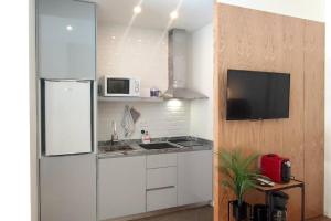 Una cocina con un refrigerador blanco y un microondas. en Sweet Domus & Terrace Citycenter, en Vila Nova de Famalicão