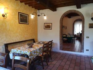 a dining room with a table and chairs in a room at Podere Il Cerrone app Romilda con piscina in Fauglia