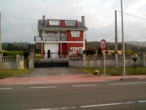 una casa roja al lado de una calle en Apartamento en las afueras en Ribadeo