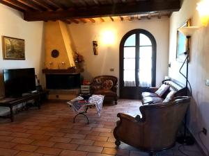 a living room with a couch and a tv at Podere Il Cerrone app Romilda con piscina in Fauglia