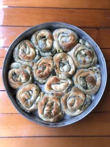 uma panela cheia de bagels numa mesa de madeira em Bujtina Sherifaj em Valbonë