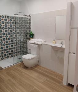 a bathroom with a toilet and a sink and a shower at Mi Casita De Garraf in Garraf