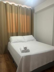a bed with a pair of scissors on top of it at AP Smart Quirino in Campinas