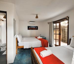 Habitación de hotel con 2 camas y balcón en Pousada Zen Caraiva, en Caraíva