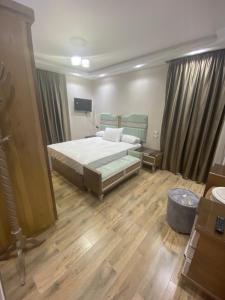 1 dormitorio con 1 cama grande y suelo de madera en فندق وشقق المهندسين جامعه الدول العربية en El Cairo