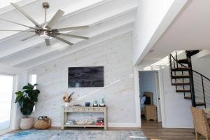 sala de estar con ventilador de techo y escalera en Enjoy Sunrise every morning Beach House, en Ponte Vedra Beach