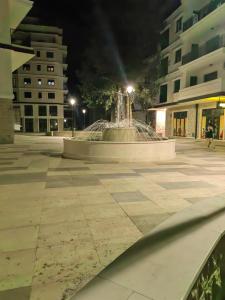 a fountain in the middle of a courtyard at night at Apartman Herc in Trebinje