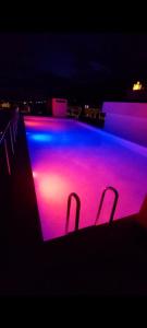 a swimming pool lit up with purple and blue lights at Apartman Herc in Trebinje