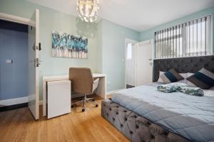 a bedroom with a bed and a desk and a chair at Mega Flat Near Arndale City Centre in Manchester