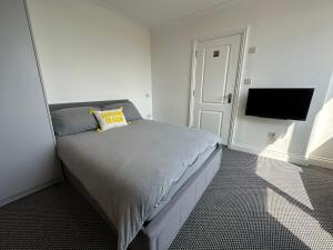 Stylish Modern, 1 Bed Flat, 15 Mins To Central London في هيندون: غرفة نوم بسرير وتلفزيون بشاشة مسطحة