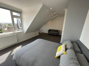 a bedroom with a couch and a large window at Stylish Modern, 1 Bed Flat, 15 Mins To Central London in Hendon