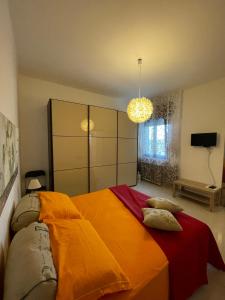 una camera da letto con un letto grande con una coperta arancione di Panorama sui trulli ad Alberobello