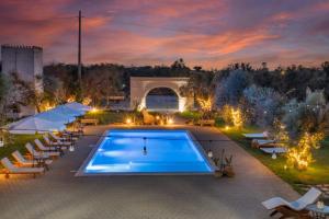 a swimming pool with chairs and a bridge in the background at Li Canali Reali in Mesagne