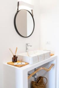 La salle de bains est pourvue d'une coiffeuse avec un miroir et un lavabo. dans l'établissement Li Canali Reali, à Mesagne