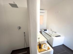 Baño blanco con lavabo blanco y espejo en Li Canali Reali en Mesagne