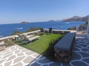 een patio met stoelen en uitzicht op het water bij Aegean Blue in Panteli