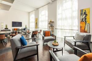 ein Wartezimmer mit Stühlen, Tischen und Fenstern in der Unterkunft Sheraton Hannover Pelikan Hotel in Hannover