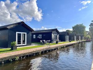 rząd domów na brzegu rzeki w obiekcie Waterpark Giethoorn w mieście Giethoorn