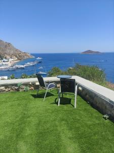 een tafel en twee stoelen op het gras bij Aegean Blue in Panteli