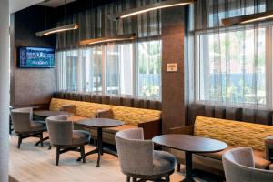 uma sala de jantar com mesas, cadeiras e janelas em SpringHill Suites by Marriott Miami Doral em Miami