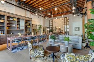 a restaurant with tables and chairs in a room at Trilogy Hotel Montgomery, Autograph Collection in Montgomery