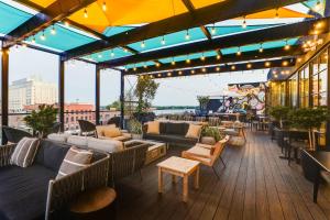 a rooftop patio with couches and tables and lights at Trilogy Hotel Montgomery, Autograph Collection in Montgomery